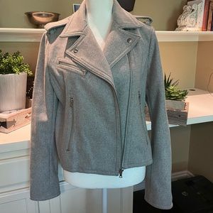 Asymmetrical-zip placket with wide flap with zipper detail on cuff of sleeves.